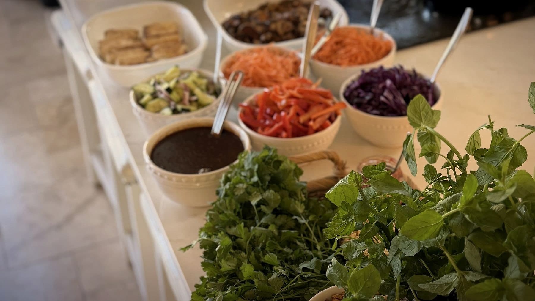 A build-your-own lettuce wrap bar by Chef Lauren Lawless, with bowls of fresh vegetables, sauce, herbs and peanuts